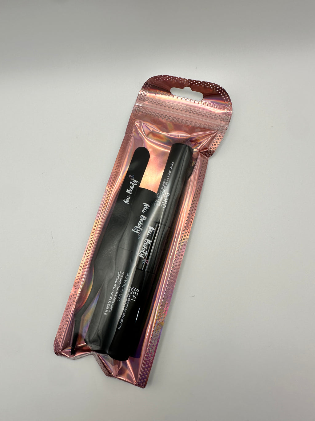 Black eyeliner pencil in a rose gold packaging on a gray background