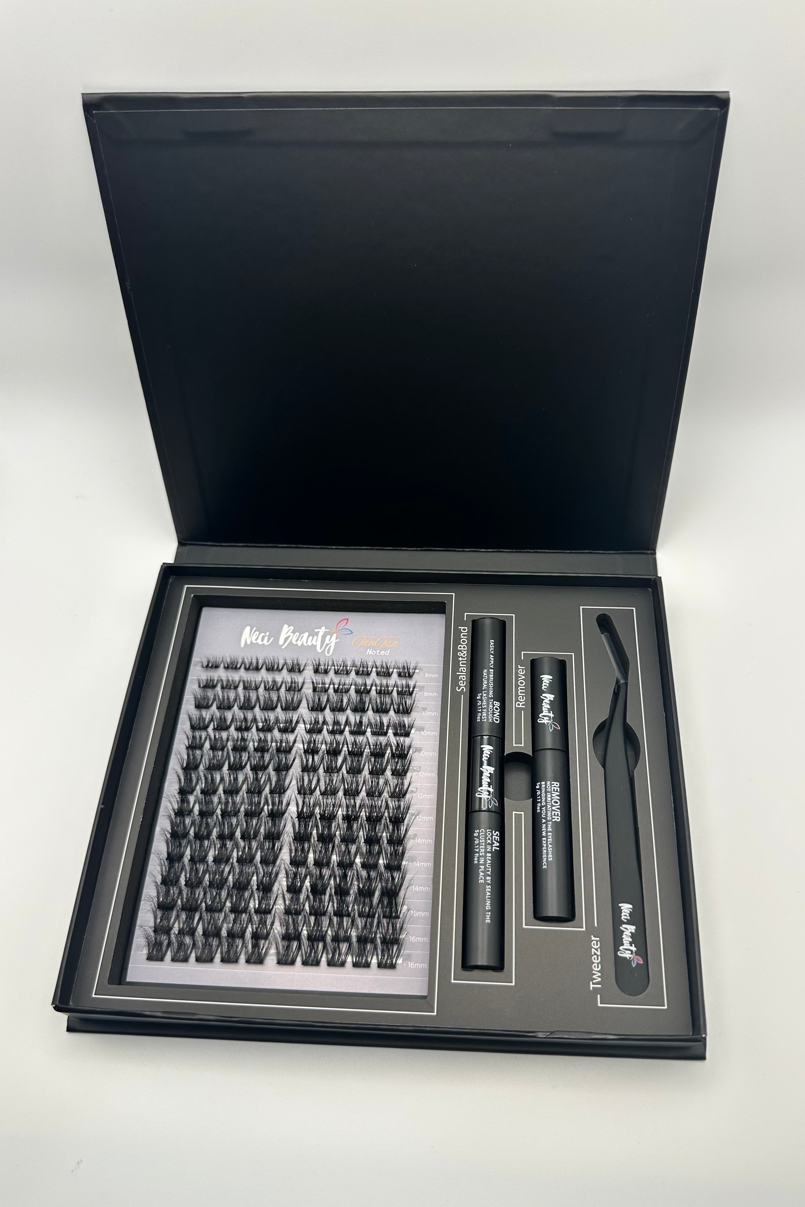 Eyelash extension kit with open black box on a white background