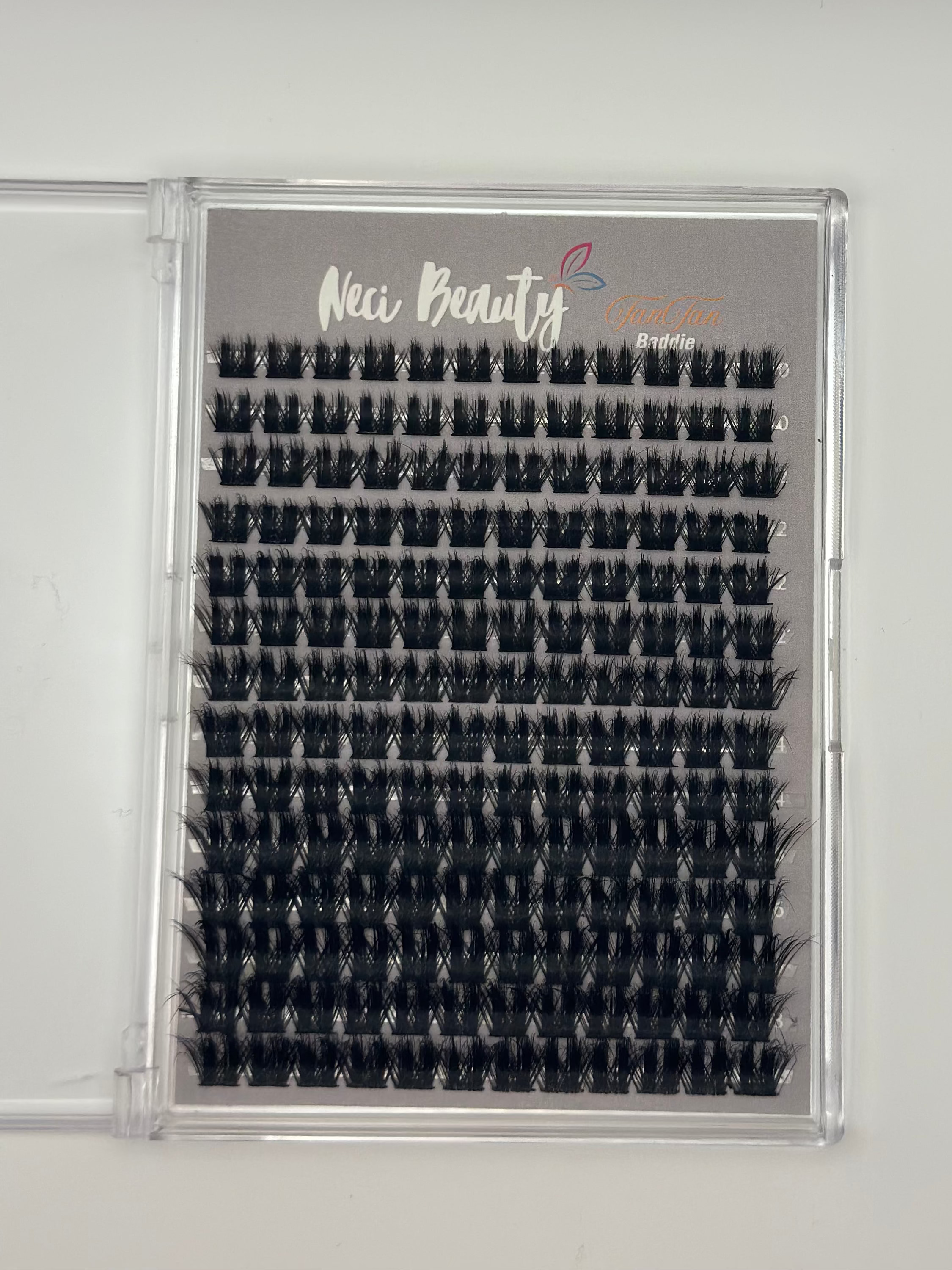 Eyelash extension tray with 'New Beauty' branding on a gray background