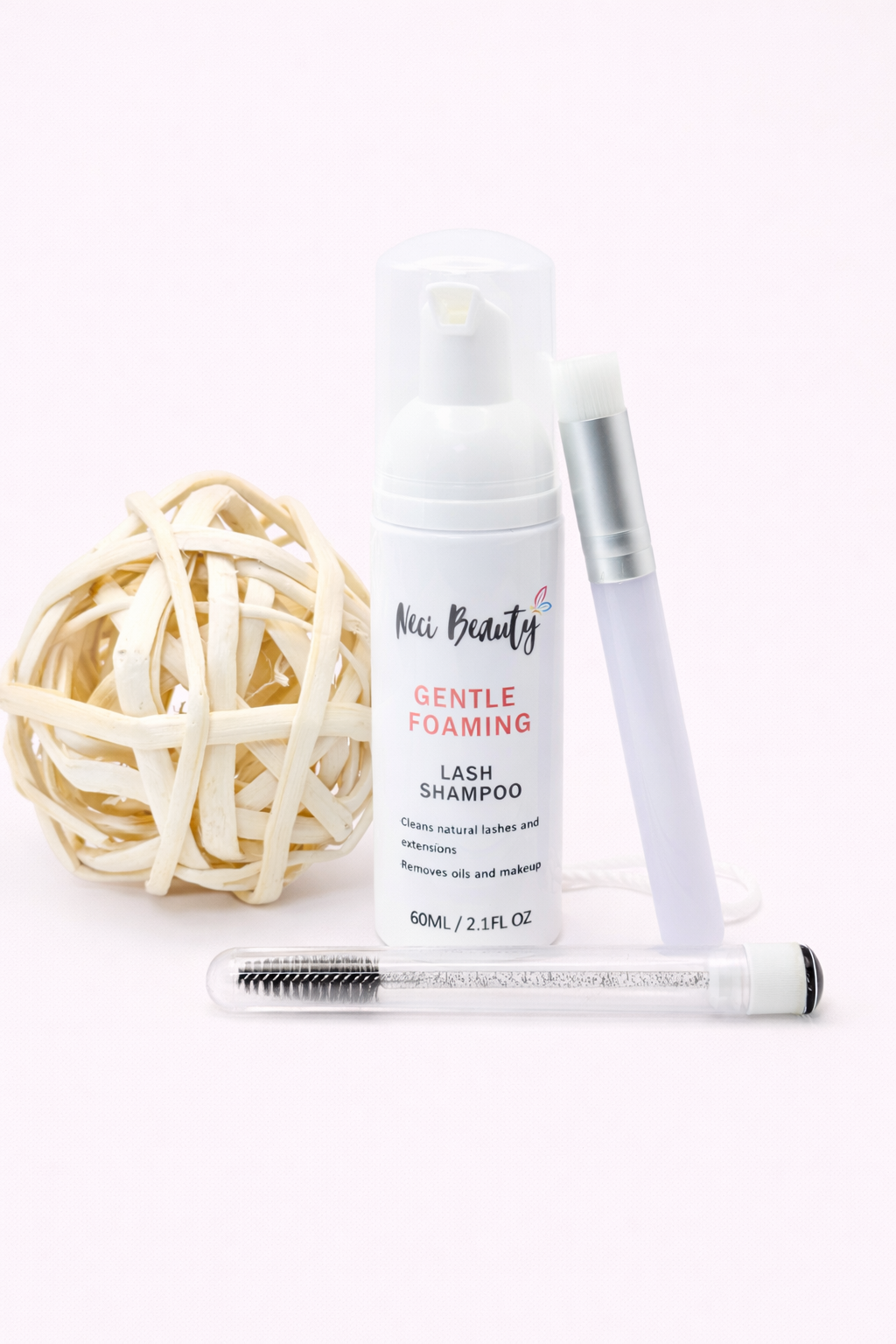 Lash shampoo, brush, and lashes on a white background