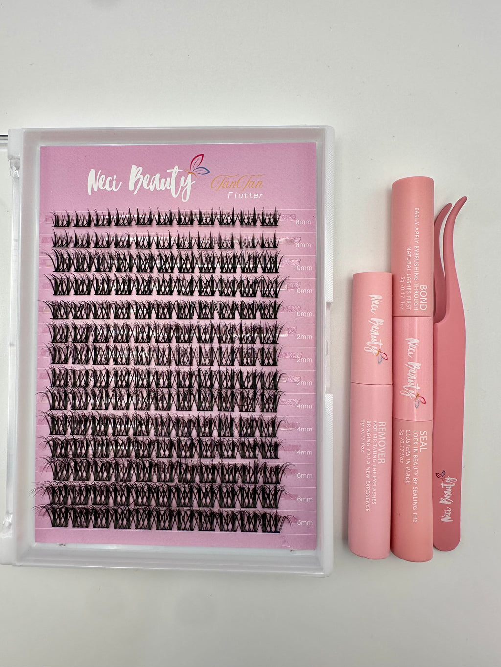 Set of false eyelashes with applicator and tweezers on a white background