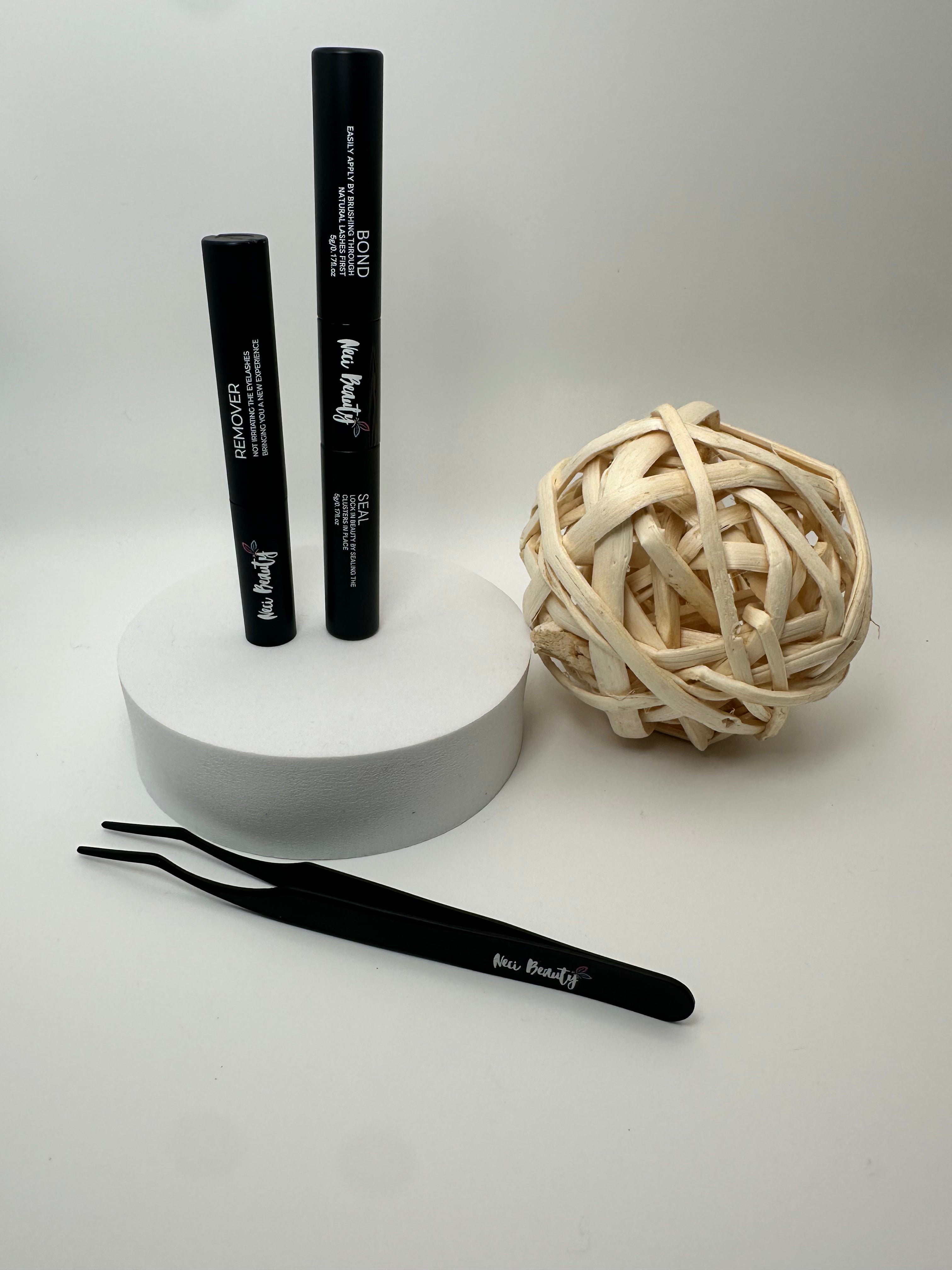 Two black makeup brushes and a ball of twine on a white surface