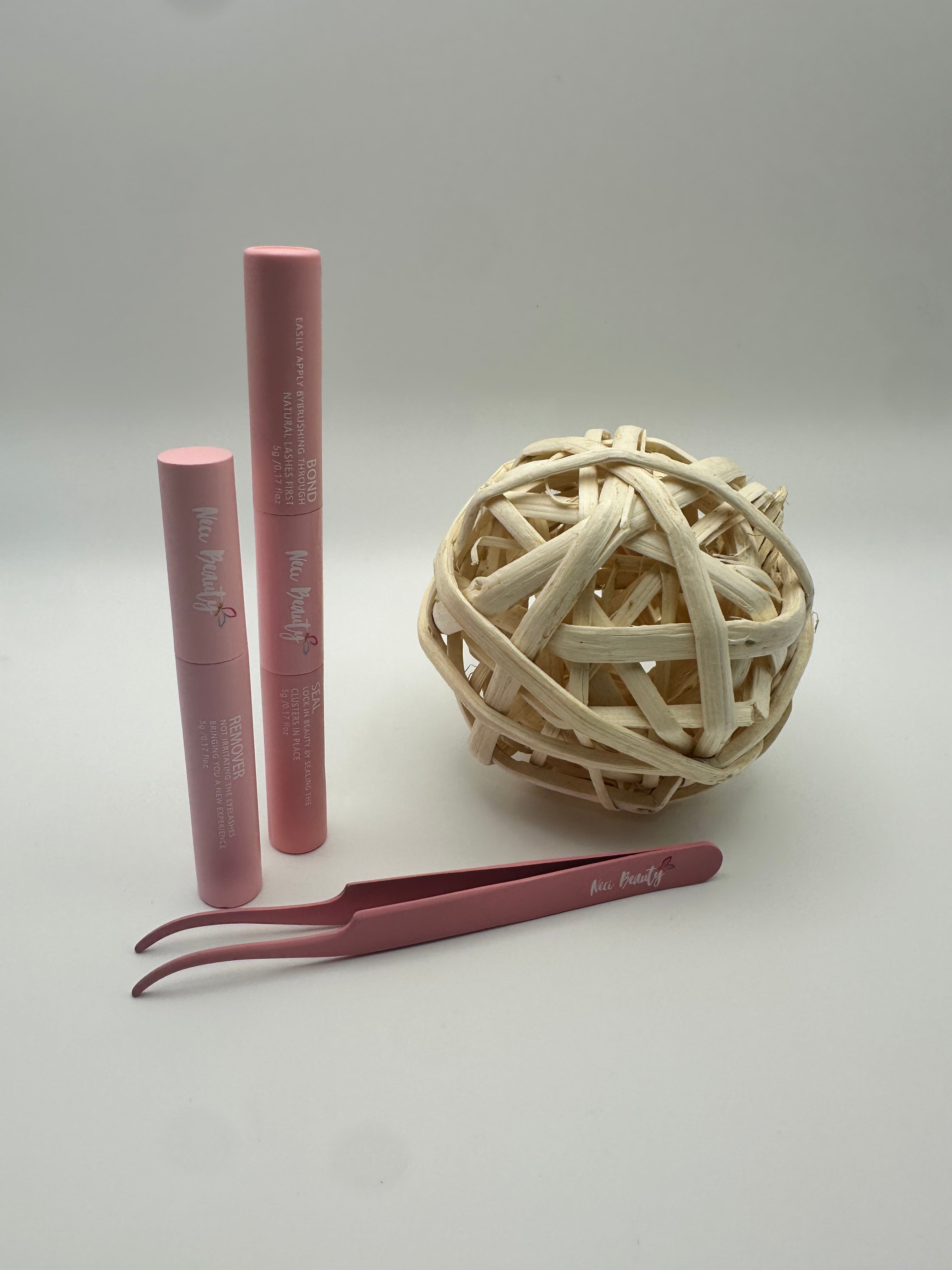 Two lip glosses and a pair of tweezers on a light gray background with a ball of twine.